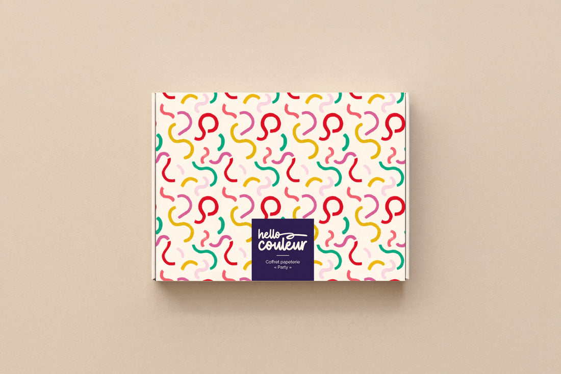 Coffret papeterie Party fermé, boîte crème parsemée de courbes colorées signée Hello couleur