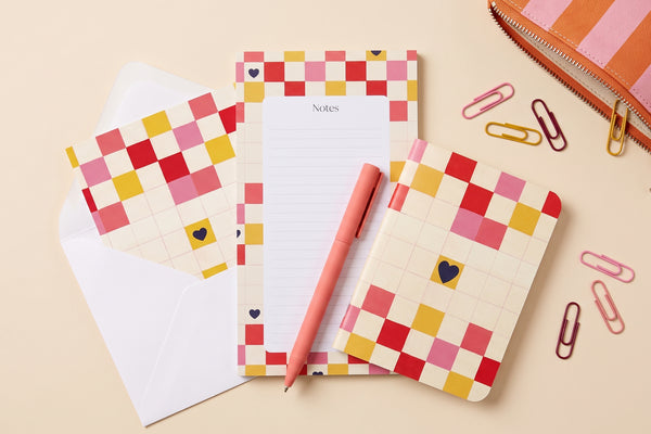 Pack Damier cœur déballé à plat : bloc-notes, carnet à damier, enveloppe et crayon