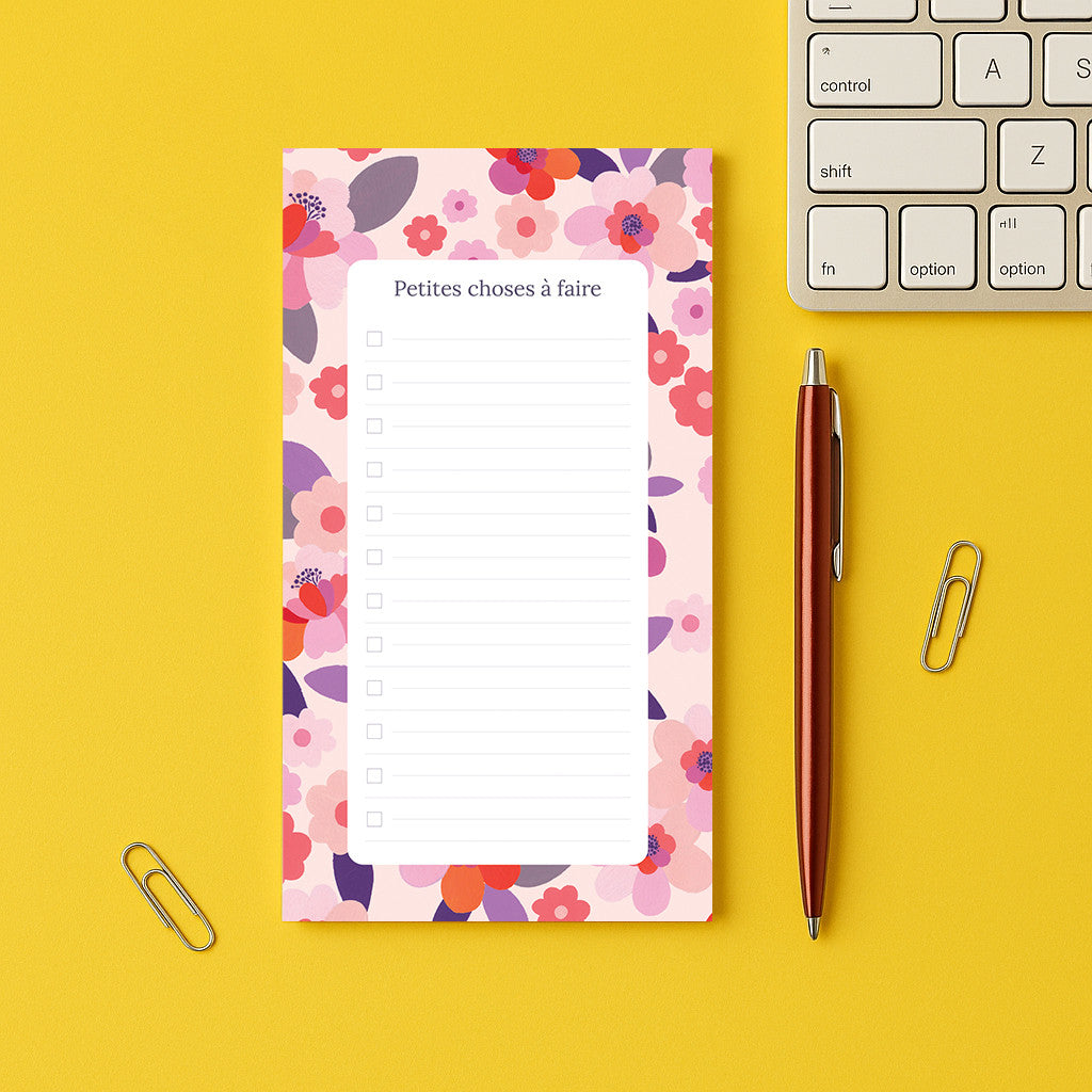 Bloc-notes Sakura posé sur un bureau jaune, liste à cocher encadrée de fleurs de cerisier