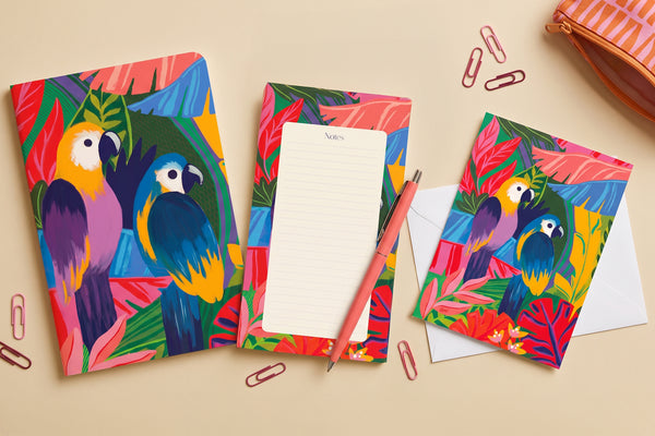 Pack Les Perroquets déballé à plat : carnet tropical, bloc-notes, carnet de poche et enveloppe