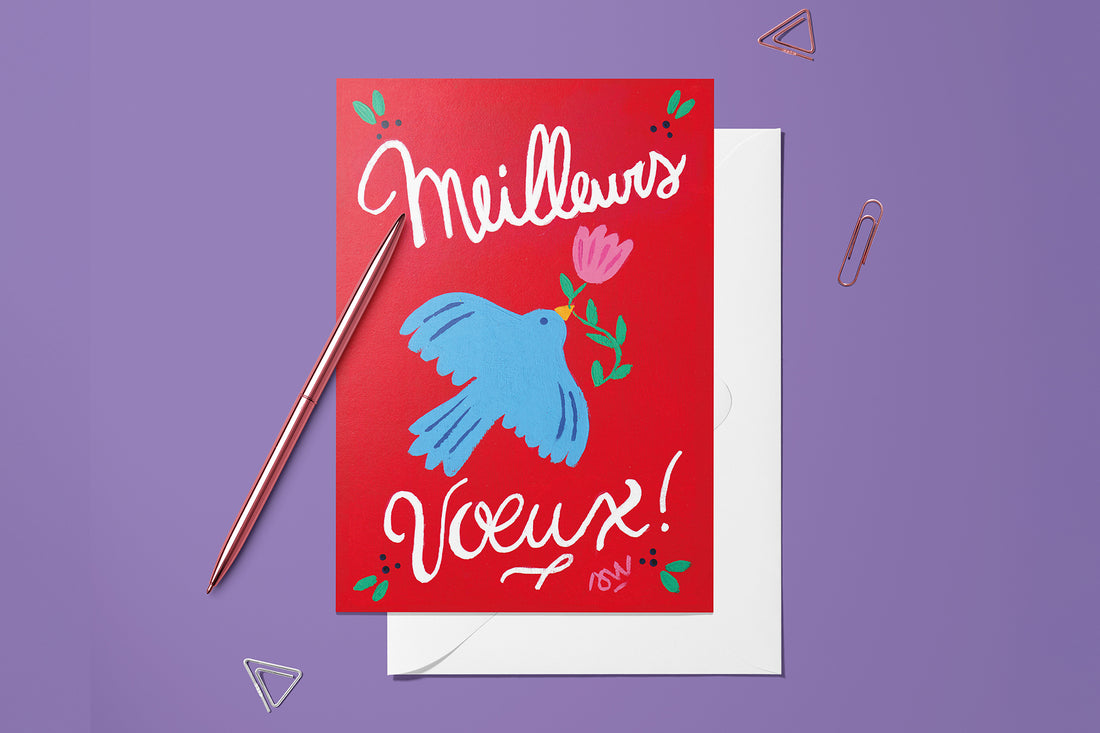 Carte Meilleurs Vœux rouge du pack thème Noël, posée avec un stylo doré et son enveloppe