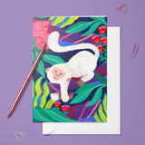 Carte César du pack thème Animaux, singe blanc dans un feuillage tropical, posée avec un stylo doré