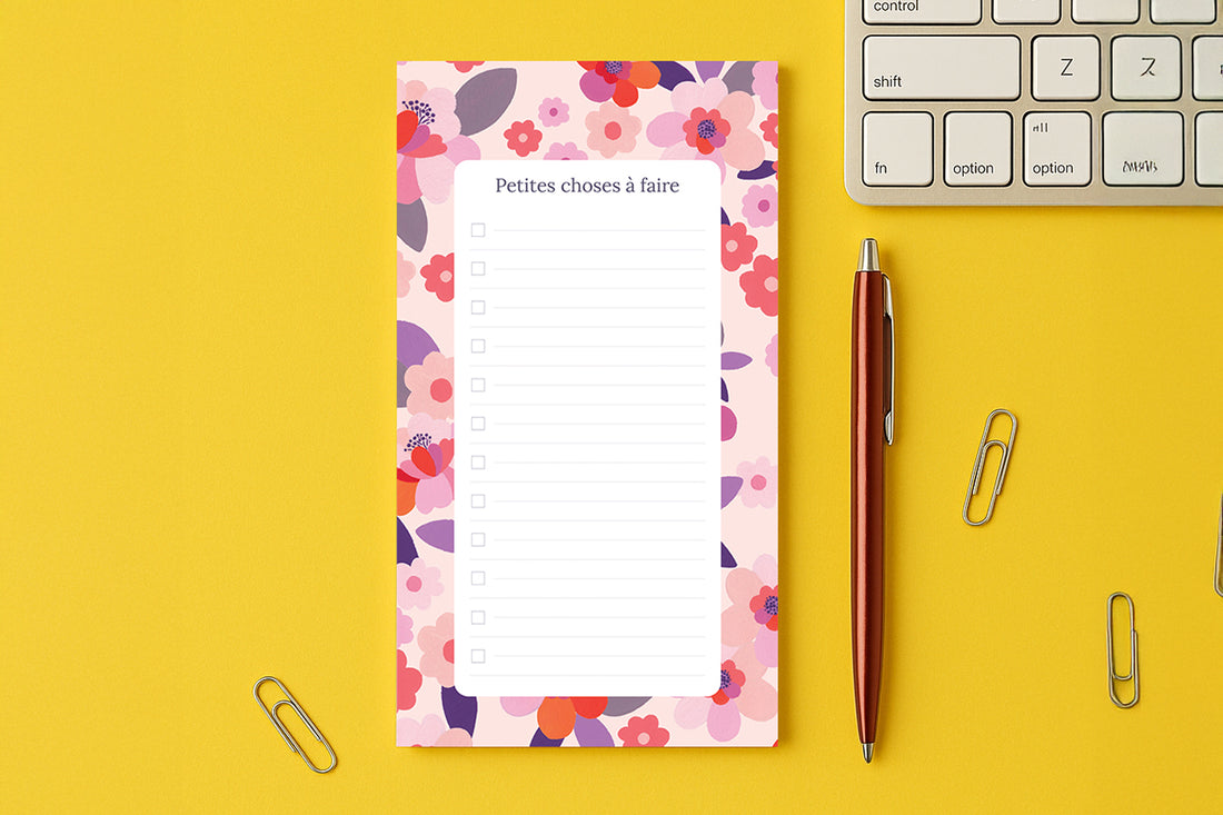 Bloc-notes du pack Sakura posé sur un bureau jaune, près d'un clavier et d'un stylo