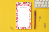 Bloc-notes du pack Sakura posé sur un bureau jaune, près d'un clavier et d'un stylo