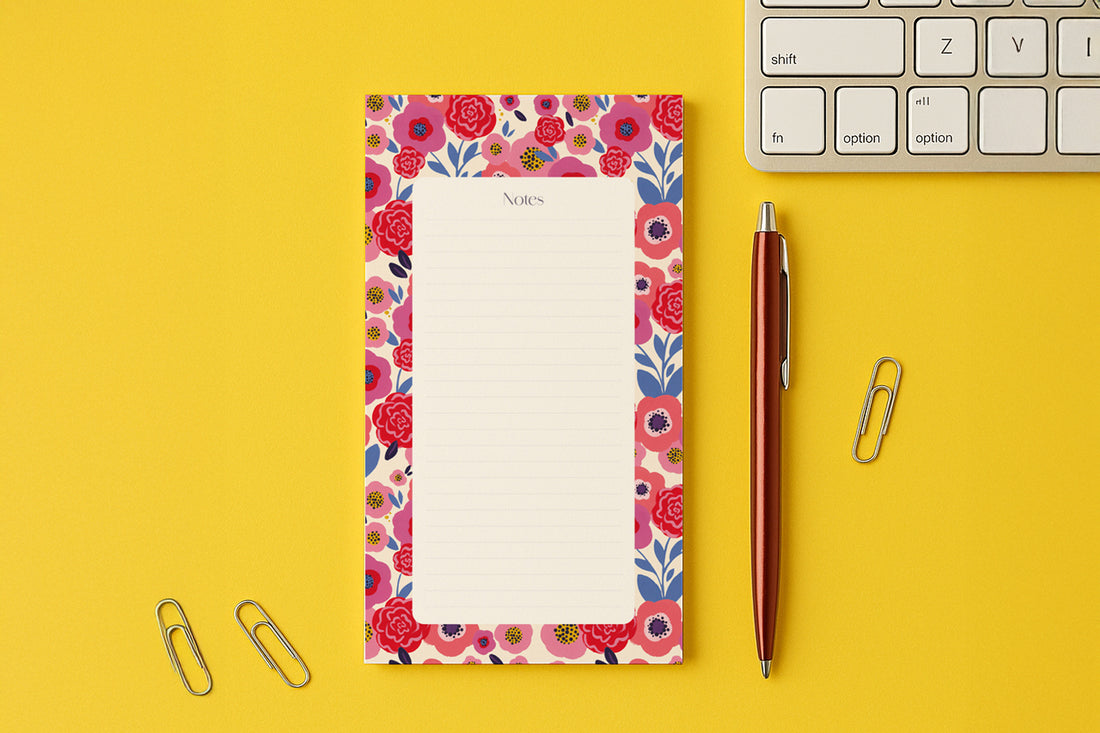 Bloc-notes du pack Floral posé sur un bureau jaune, près d'un clavier et d'un stylo