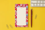 Bloc-notes du pack Floral posé sur un bureau jaune, près d'un clavier et d'un stylo
