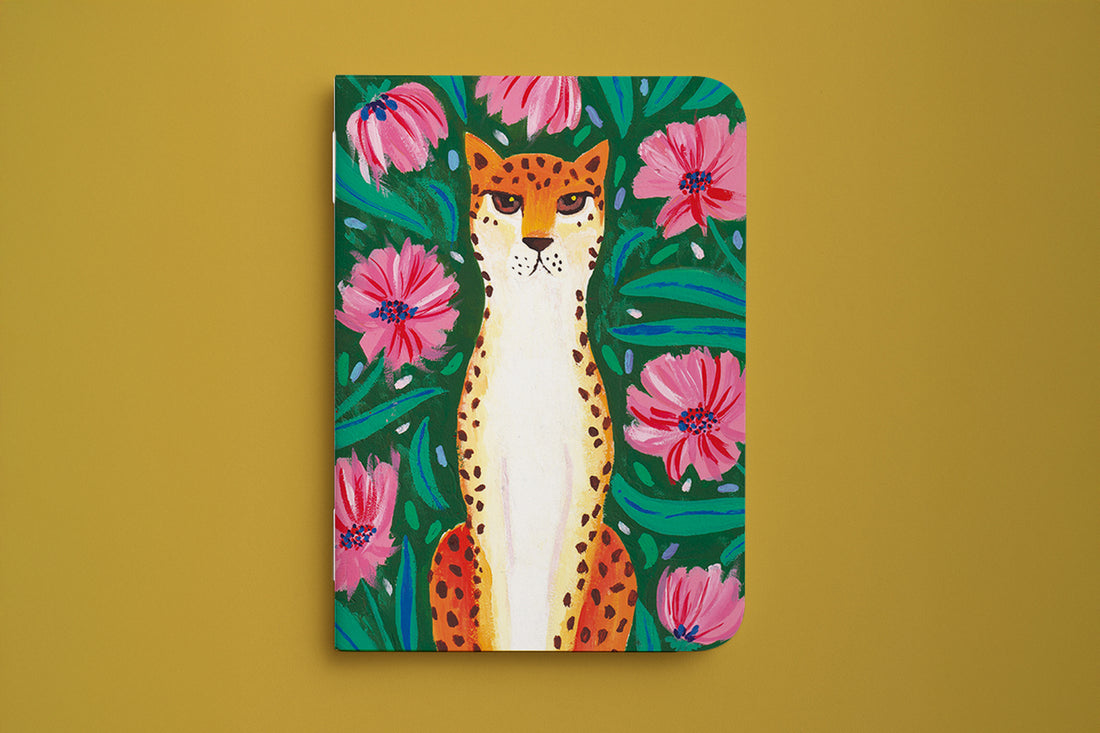 Carnet du pack guépard fleuri, couverture illustrée d'un guépard parmi de grandes fleurs roses