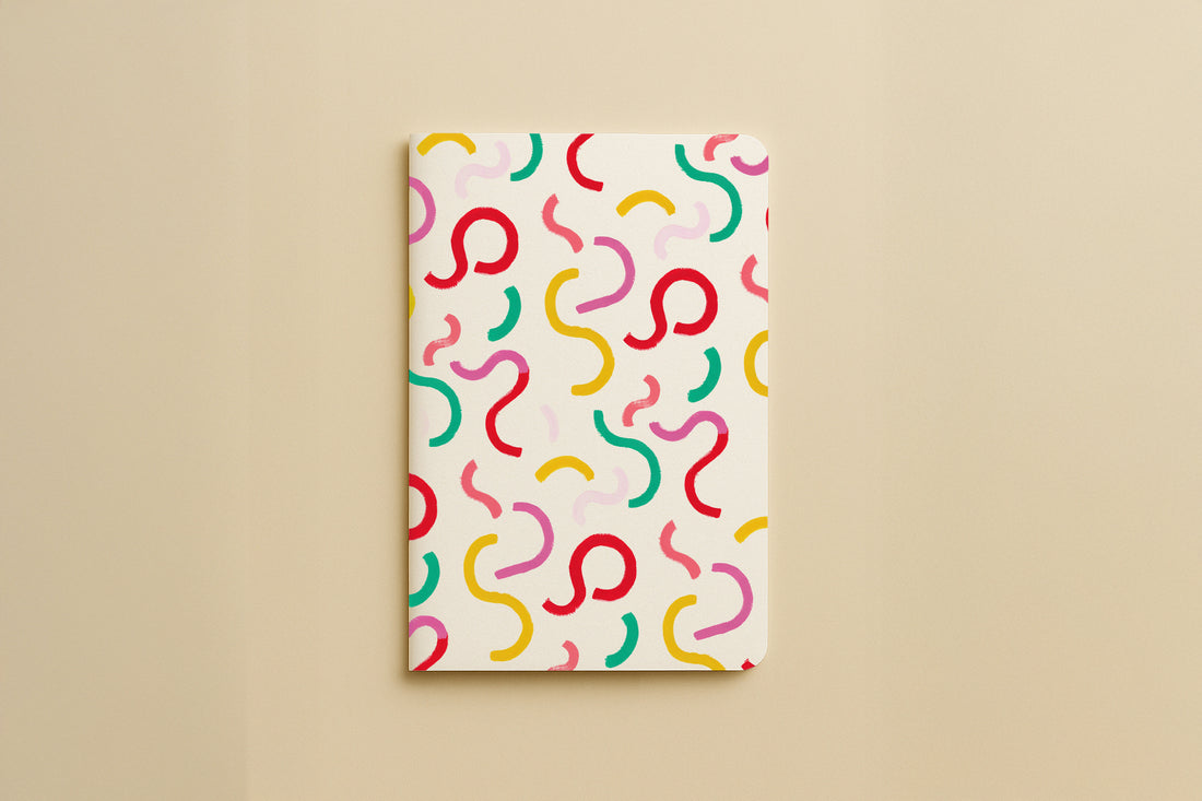 Carnet du pack Danse des courbes, couverture crème parsemée de courbes colorées