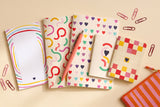 Grand pack Danse des courbes déballé à plat : bloc-notes, carnets, trombones et stylo assortis