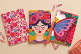 Pack 3 carnets A5 au choix présenté à plat : carnets floral, Frida et papillon avec crayons et trombones