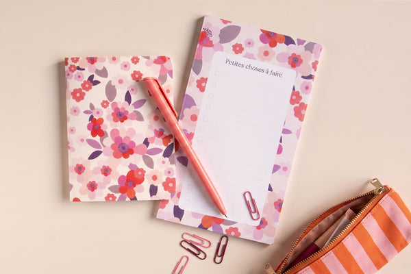 Pack Sakura déballé à plat : carnet aux fleurs de cerisier, bloc-notes, stylo et trousse rayée