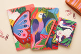 Pack Animaux colorés trio de carnets déballé à plat : carnets papillon, perroquets et singe avec un crayon