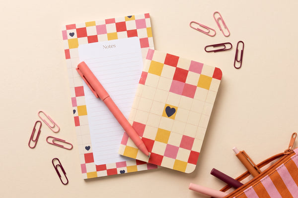 Petit pack Damier cœur déballé à plat : bloc-notes, carnet à damier, stylo et trombones