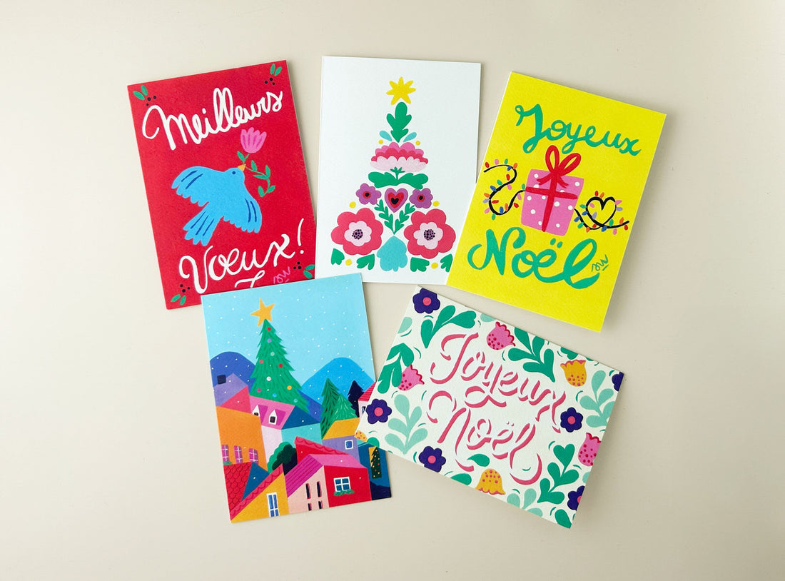 Les cinq cartes pliées du pack thème Noël disposées à plat sur un fond crème