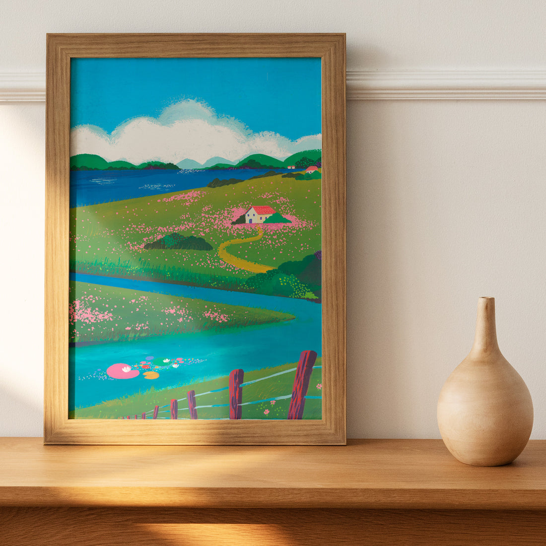 Peinture originale À la campagne encadrée en bois, posée sur une étagère à côté d'un vase en bois tourné