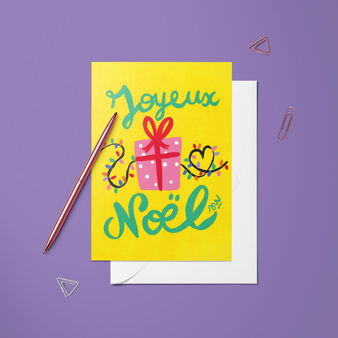 Carte pliée Noël Paquet cadeaux posée avec un stylo doré et son enveloppe, paquet cadeau sur fond jaune