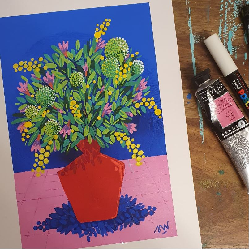 Tirage d'art Mimosa et Vase rouge posé sur l'établi de l'atelier, entouré de tubes de peinture et de pinceaux