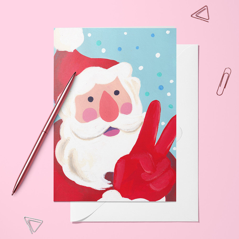 Carte pliée Selfie du Père Noël posée avec un stylo doré et son enveloppe, Père Noël sous la neige