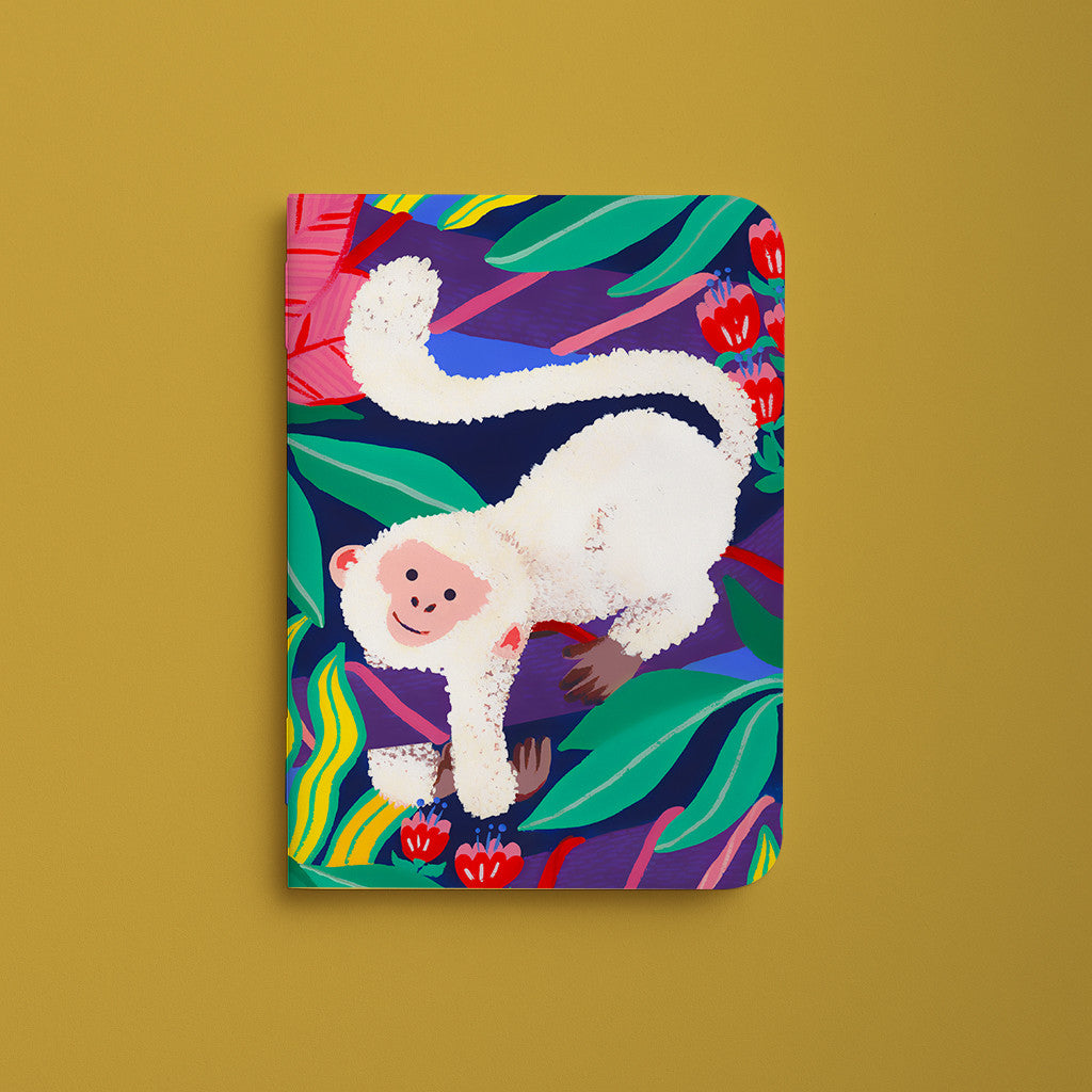 Carnet de poche César, couverture illustrée d'un singe blanc parmi les feuillages verts et les fleurs rouges