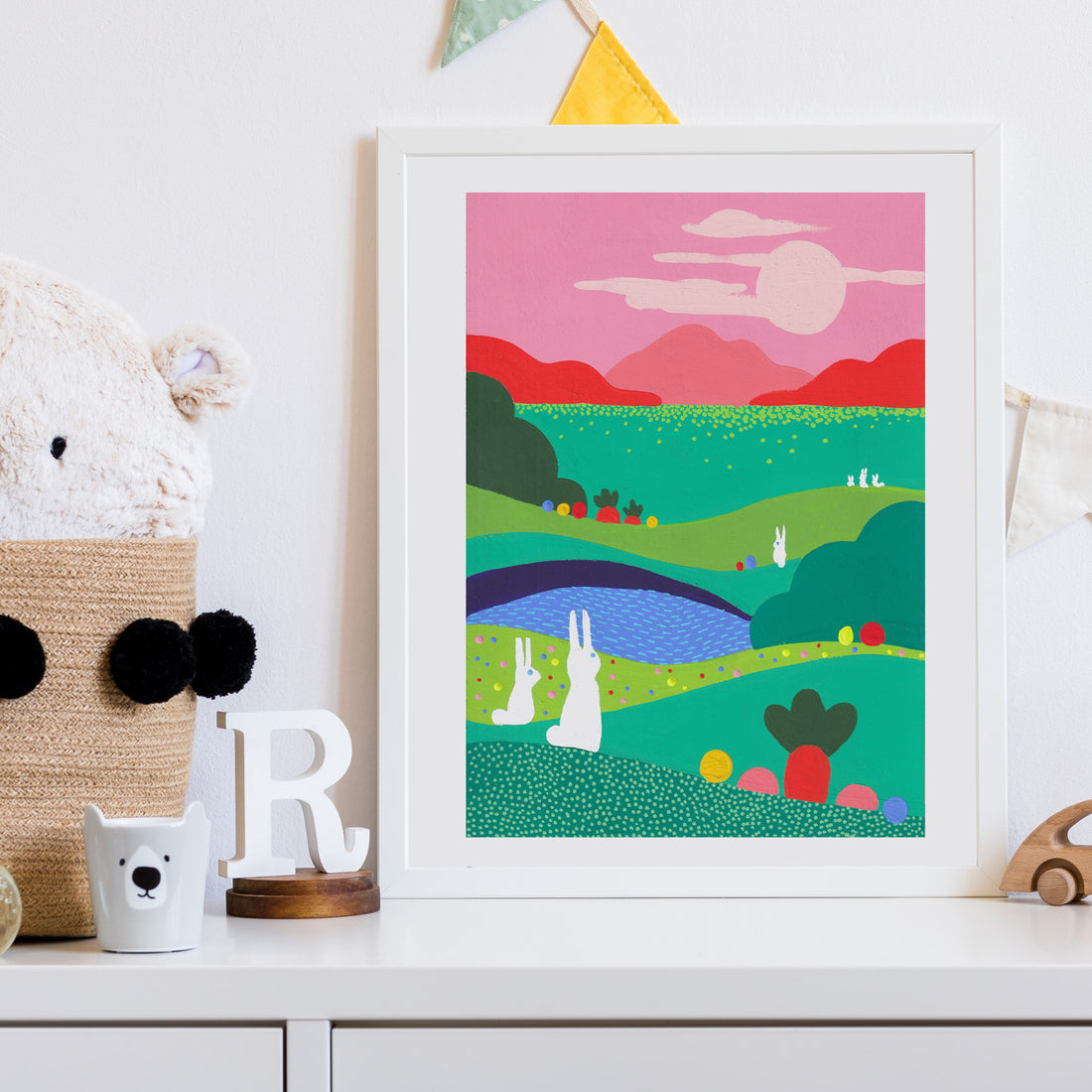 Tirage d'art Chasse aux œufs encadré en blanc dans une chambre d'enfant, sur une étagère avec peluche et guirlande