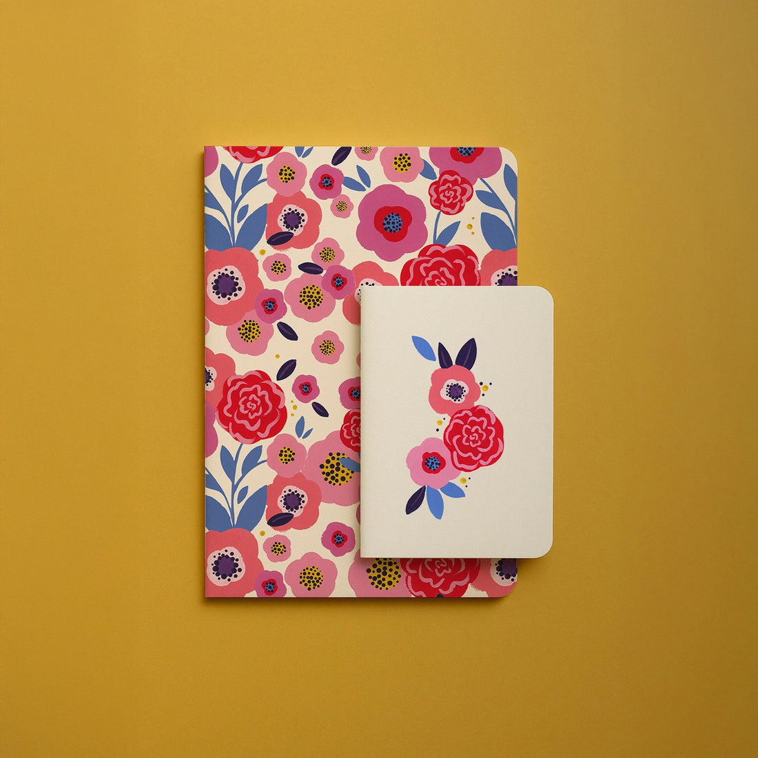 Carnet A5 Festival de fleurs présenté avec un carnet de poche assorti sur fond moutarde