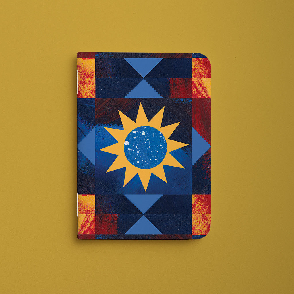 Carnet de poche Orion, couverture bleu nuit à motifs géométriques autour d'un soleil jaune